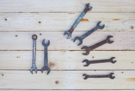 Rusty wrench on white wood background