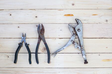 Locking pliers on white wooden background