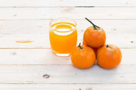 Glasses of orange juice and fruits on wooden tableの写真素材