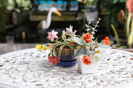 Artificial flower in the vase on the tableの写真素材