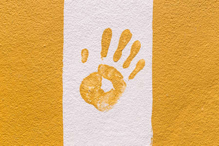 Hand print on orange and white wall backgroundの写真素材