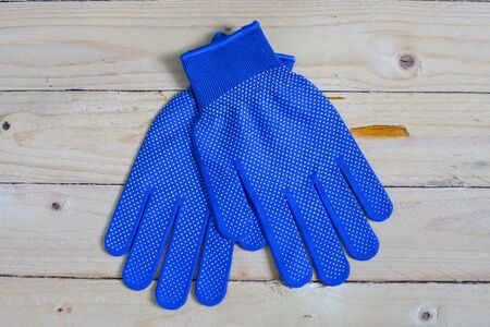 Blue gloves on wooden background taken in top viewの写真素材