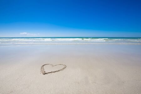 Beautiful beach with heart print and blue sky backgroundの写真素材