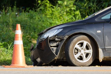 black car frond damage on the road white traffic cone