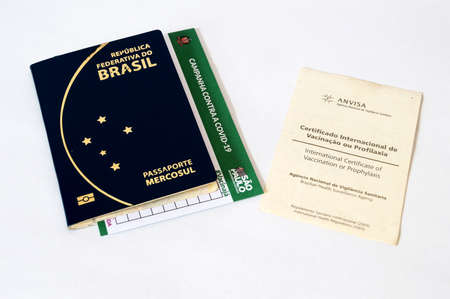 SOROCABA, SAO PAULO - MAY 16, 2022: Brazilian passport with Covid vaccine wallet inside and yellow fever vaccine certificate next to itのeditorial素材