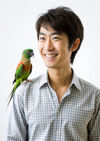 Young man holding a parrot, isolated on white background, asianの素材