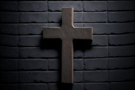 Concept of religion wooden cross on fresh black plastered brick wallの素材