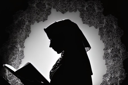 Woman in silhouette reading from the Quranの素材