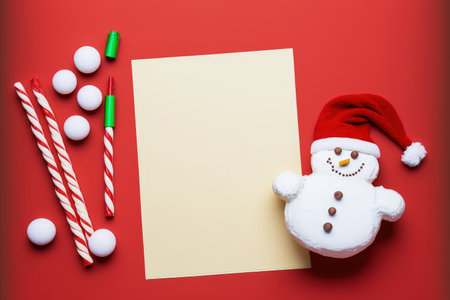 Blank wish list for Christmas with candies and a snowman on a red backgroundの素材