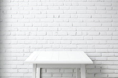 Blank white table with copy space against a brick wall as a backdropの素材