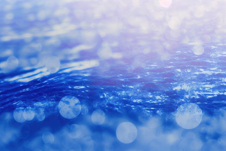 Defocus blurred clear calm water surface texture in a translucent blue tone with splashes and bubbles. a modern abstract background of nature. Water waves with copy space in the sun. dazzling blue wの素材