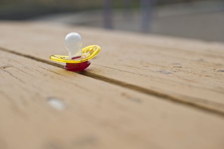 A forgotten pacifier on a picnic tableの写真素材