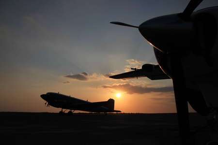 Two air planes silhouetted sunsetの写真素材