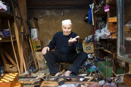 Fez, Morocco - April 11, 2016: An artisan showing a spinning top in his shop in the Fez Medina.のeditorial素材