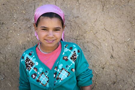 Errachidia, Morocco - April 12, 2016: Young Berber girl poses in front of her home in a small Berber village in the Ziz Valley, near Errachidia, Morocco.のeditorial素材