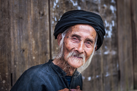 Old Chinese man wearing traditional clothes in Dazhai, Guangxi, China; Concept for travel in Chinaのeditorial素材