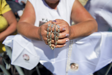 Fatima, Portugal - May 13, 2014: Detail of a woman holding a rosary at the Sanctuary of Fatima during the celebrations of the apparition of the Virgin Mary in Fatima, Portugal.のeditorial素材