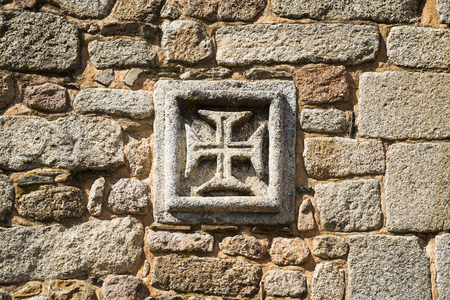 The insignia of the Order of Christ (Cross of the Order of Christ) in as old stone wall in the historic village of Idanha a Velha in Portugalの写真素材
