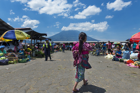 Antigua, Guatemala - April 19, 2014: Local girl wearing traditional clothing in a street market in the city of Antigua, in Guatemala, Central Americaのeditorial素材
