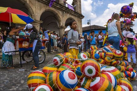 Antigua, Guatemala - April 18, 2014: Young girl selling colorful rubber balls in a street of the old city of Antigua, in Guatemalaのeditorial素材