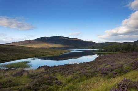 Beautiful lake surrounded by cliffs and mountains in the Highlands of Scotland in United Kingdom; Concept for travel in Scotlandの写真素材