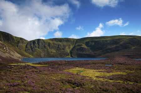 Beautiful lake surrounded by cliffs and mountains in the Highlands of Scotland in United Kingdom; Concept for travel in Scotlandの写真素材