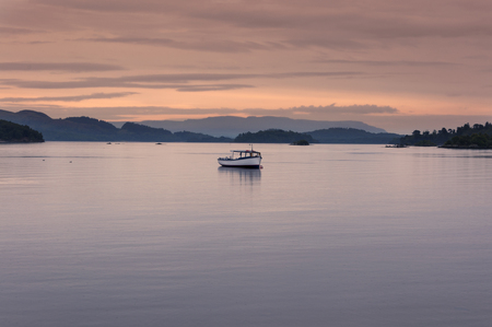 Boat in a lake at sunset in the Highlands of Scotland, United Kingdom; Concept for travel in Scotlandの写真素材