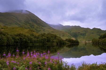Beautiful and serene landscape of a lake and mountains in the Highlands of Scotland, United Kingdom; Concept for travel in Scotlandの写真素材