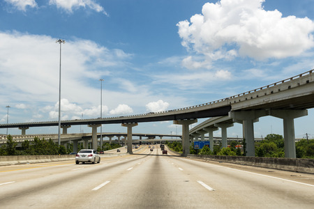 Houston, Texas - June 14, 2014: Cars in a highway in the outskirts of the city of Houston with a overpass and stack intercharges, USA.のeditorial素材