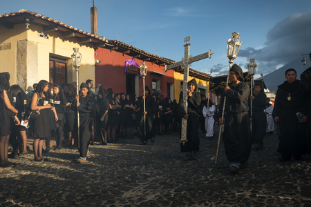 Antigua, Guatemala - April 19, 2014: Man wearing black robes and hoods in a street of the old city...