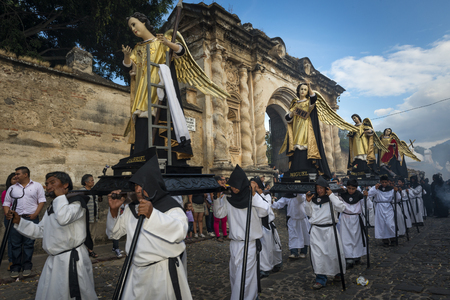 Antigua, Guatemala - April 19, 2014: Men carrying parade floats in a street of the old city of Antigua during a procession of the Holy Week, in Antigua, Guatemalaのeditorial素材