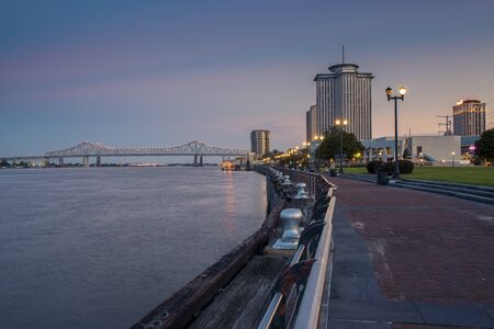 New Orleans, Louisiana - June 17, 2014: View of the Mississippi river from the city of New Orleans riverfront, with the Great New Orleans Bridge on the background in New Orleans, Louisiana, at dusk.のeditorial素材