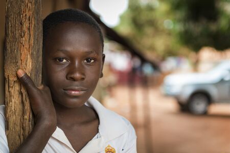 Nhacra, Republic of Guinea-Bissau - January 28, 2018: Portrait of a young boy at the entrance of his home in the town of Nhacra in Guinea Bissau, West Africaのeditorial素材