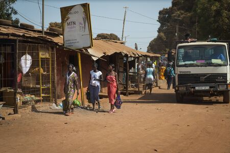 Bissau, Republic of Guinea-Bissau - January 29, 2018: Street scene in the city of Bissau with women waling along a dirt road, in Guinea-Bissau, West Africaのeditorial素材