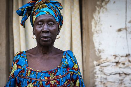 Bissau, Republic of Guinea-Bissau - January 29, 2018: Portrait of an African woman wearing a colorful dress in a slum of the city of Bissau, in Guinea-Bissau, West Africaのeditorial素材