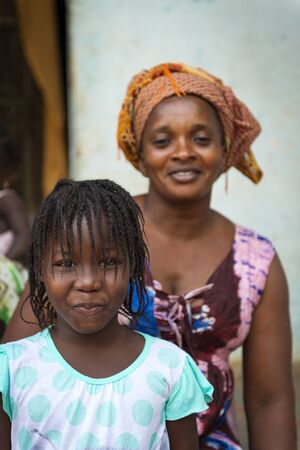 Bissau, Republic of Guinea-Bissau - January 31, 2018: Portrait of young girl and her mother at the Cupelon de Cima neighborhood in the city of Bissau, Guinea Bissau.のeditorial素材