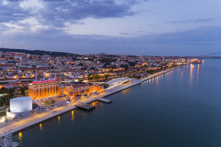 Aerial view of the city of Lisbon and the 25 of April Bridge on the background at dusk; Concept for...