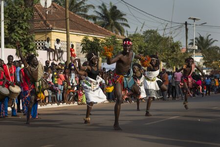 Bissau, Republic of Guinea-Bissau - February 12, 2018: Group performance during the Carnival Celebrations with men and women wearing traditional costumes in the city of Bisssau.のeditorial素材