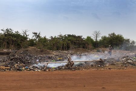 Bissau, Republic of Guinea-Bissau - February 5, 2018: Man walking in a landfill in the outskirts of the city of Bissau, in Guinea-Bissau, West Africaのeditorial素材