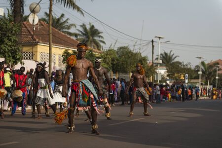 Bissau, Republic of Guinea-Bissau - February 12, 2018: Group of men and women wearing traditional clothing performing during the Carnival Celebrations in the city of Bisssau.のeditorial素材
