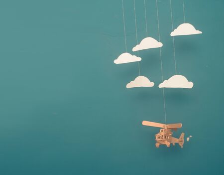 Flat lay design of travel concept with helicopter and clouds on blue background with copy space.