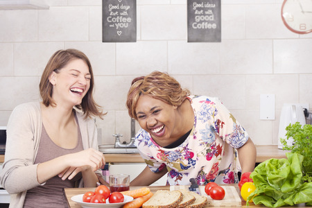 Happy friends cooking in kitchenの写真素材