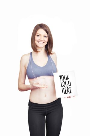 Beautiful sporty young woman holding paper for your logoの写真素材