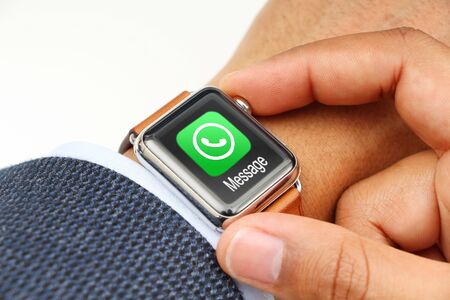 Business man checking messages with a smart watch's appの写真素材