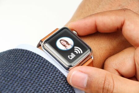 Business' man making a call with a smart watch appの写真素材