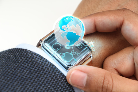close up of hand with globe hologram on smartwatchの写真素材