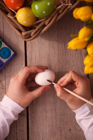 close up of woman hands coloring easter eggs