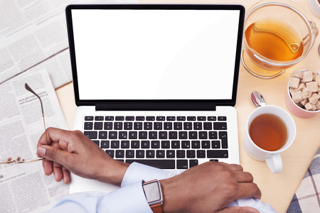 Using a computer while drinking teaの写真素材