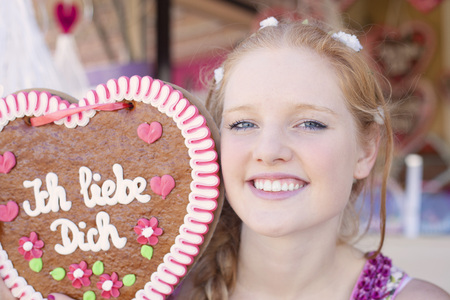 German girl with a traditional Oktoberfest's gingerbread heartの写真素材