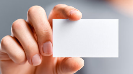 Man's hand displaying an empty white business card in a professional presenting gesture.の素材